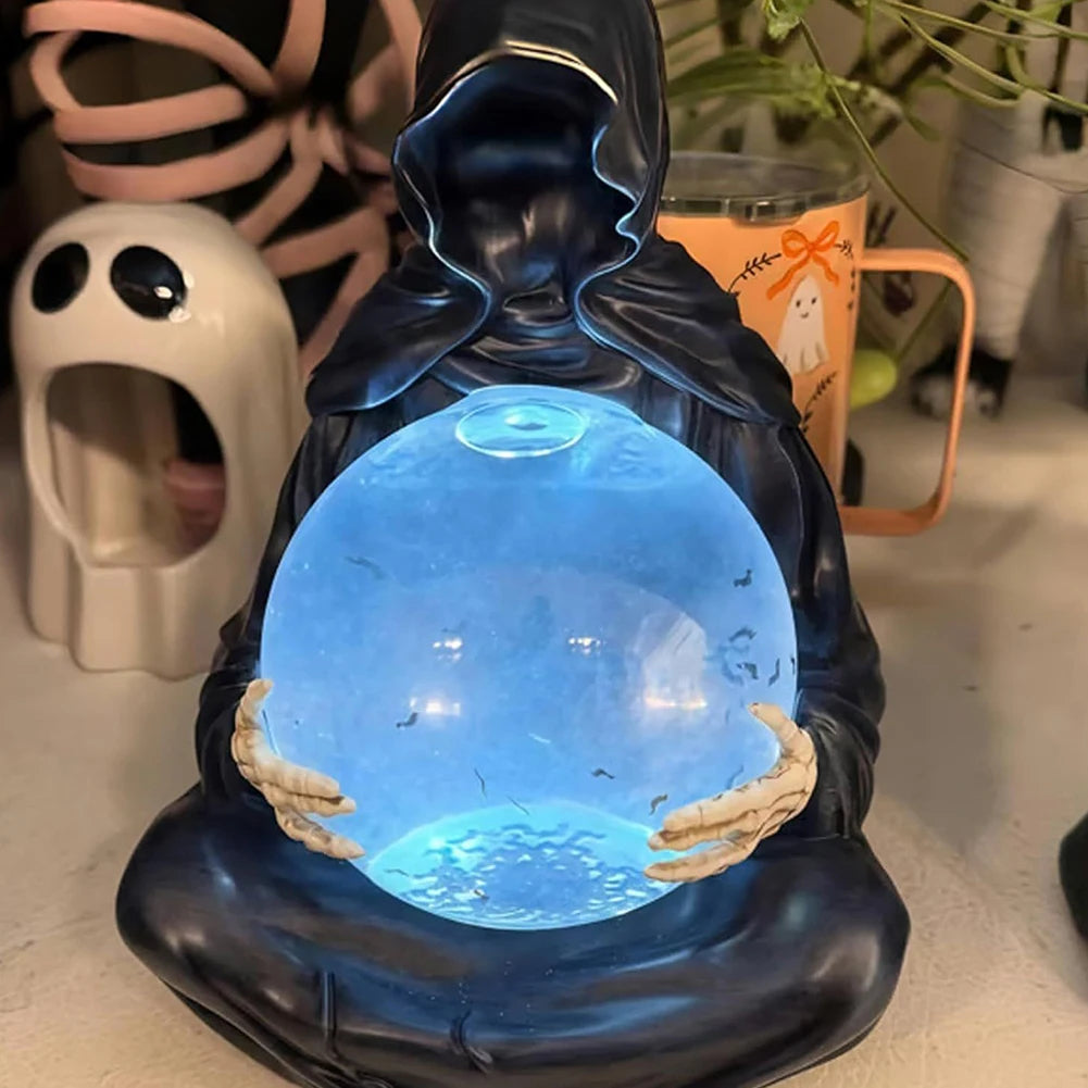 Grim reaper resin figure holding a glowing crystal ball with bats inside